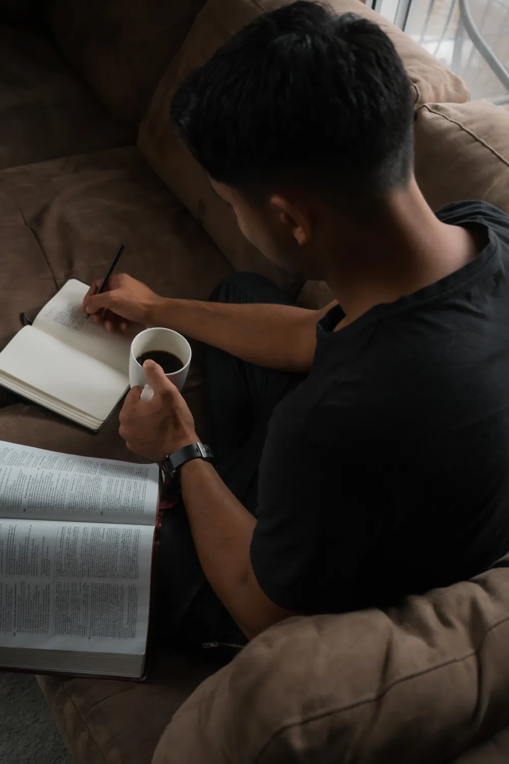 Will Abriel prenant des notes, une Bible ouverte à côté de lui